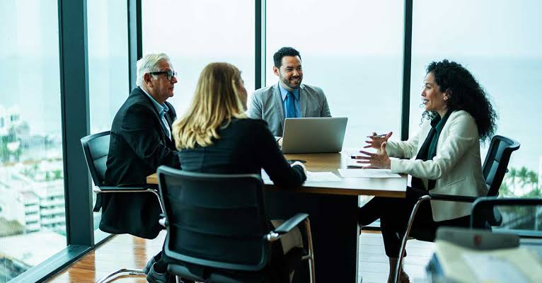 High level professionals engaging in strategic networking after reviewing bohemian grove photos